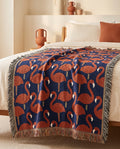 The Flamant throw, jacquard-woven cotton, on a bed